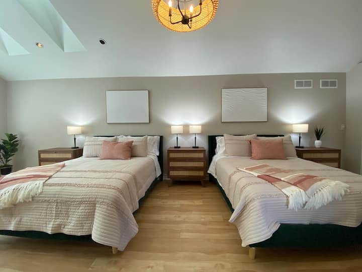 Spacious and airy bedroom with vaulted ceilings and warm natural light.