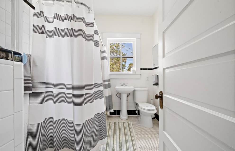 Upstairs bathroom shower and tub combination at White Magnolia Galveston