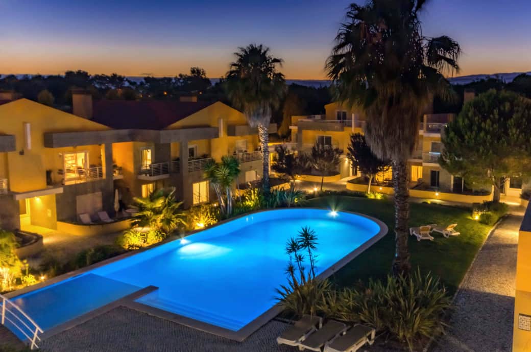 Condominium pool illuminated at night, seen from the comfort of your private rooftop Condominium pool illuminated at night, seen from the comfort of your private rooftop