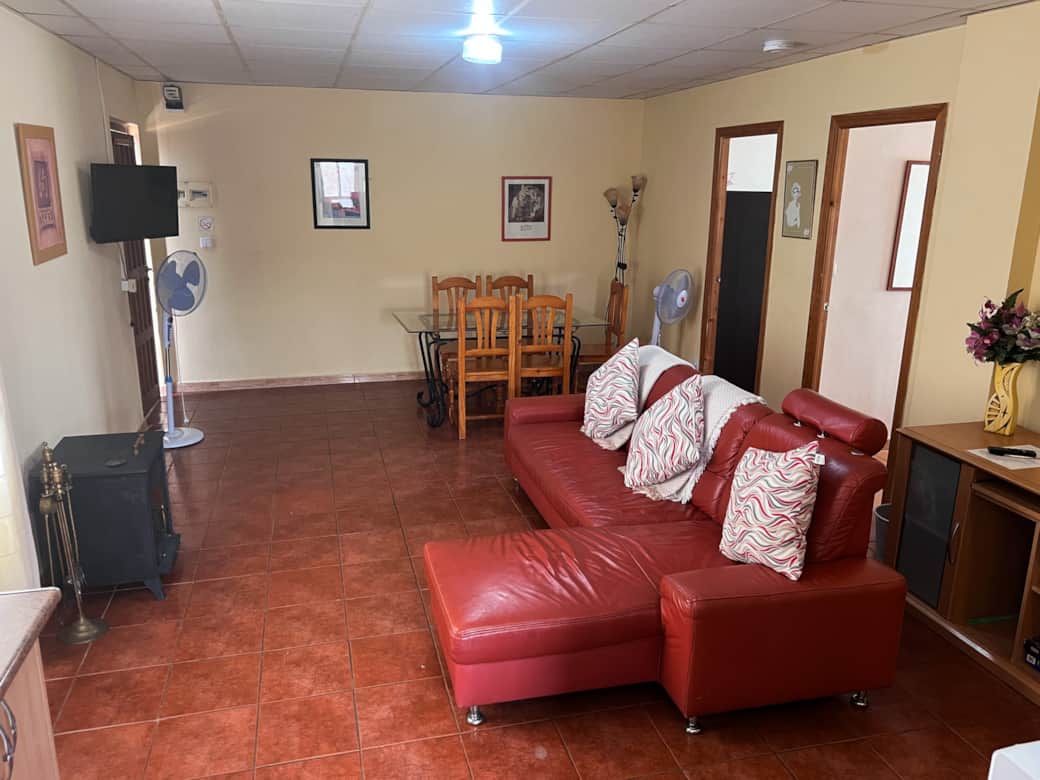 Área de salón con sofá y mesa de comedor