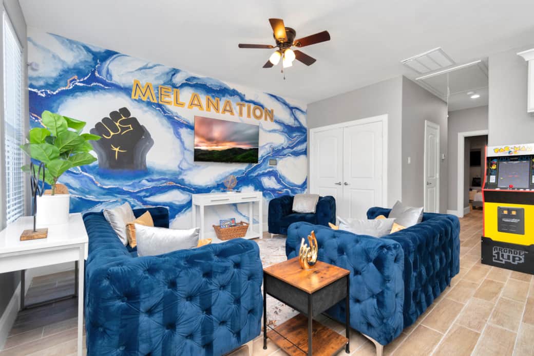 MelaNation! Living Room with 3 seater sofa, single couches and 75 inch TV