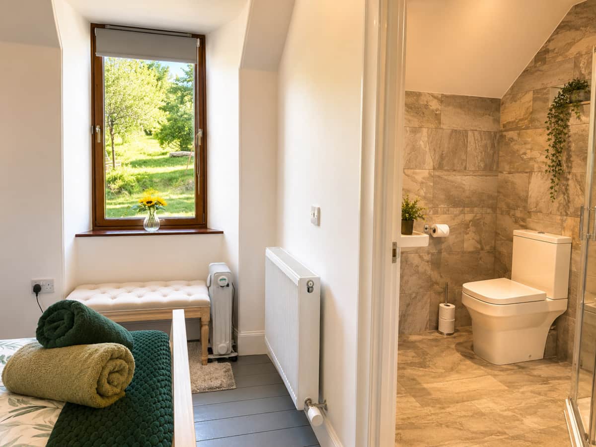 Bedroom 3 with its en-suite, seen through the open doorway.