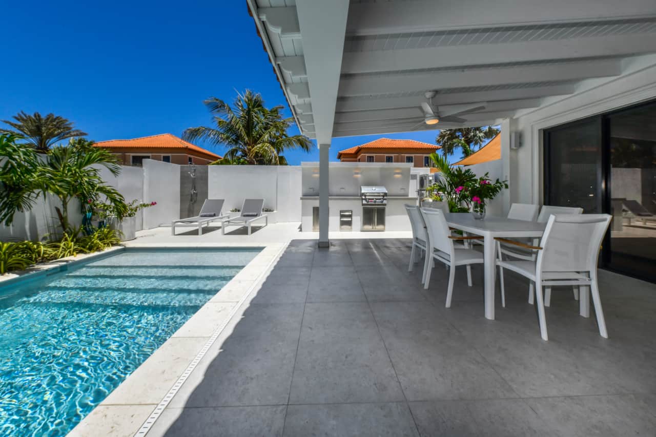 Private backyard with pool, loungers, BBQ, outdoor shower, and dining table 