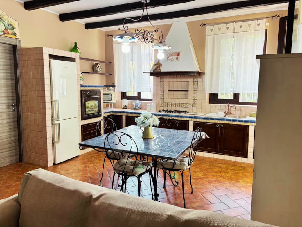 Cucina con tavolo in ceramica ideale per gruppi e smart working.