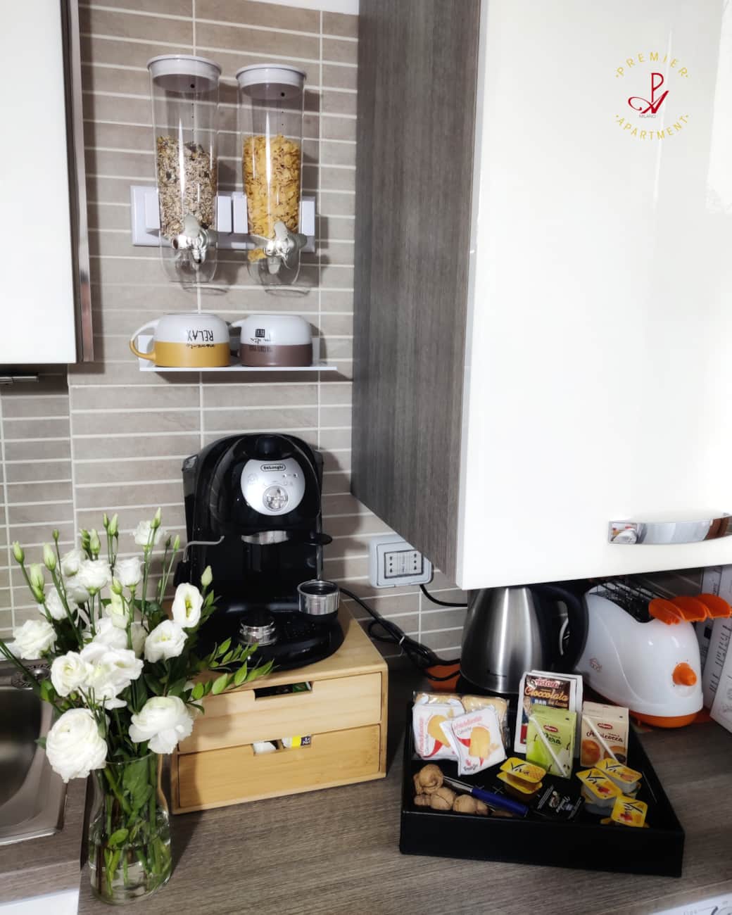 Detalle de la cocina con cafetera, tetera, tostadora y oferta de desayuno.