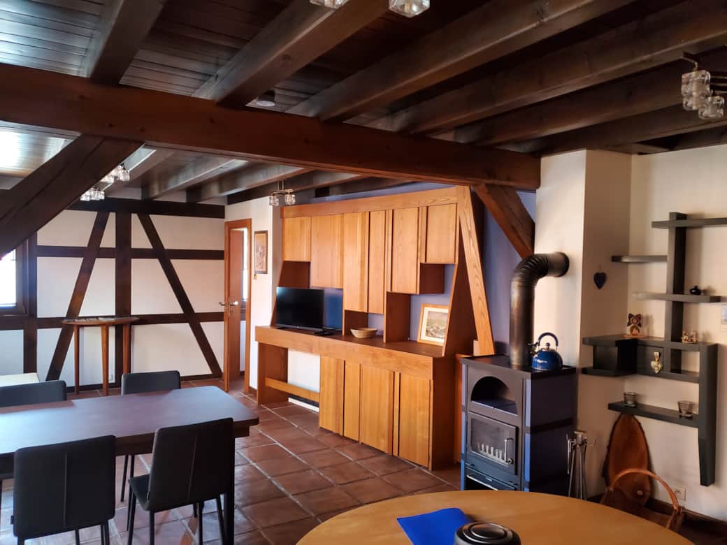 Une pièce de vie chaleureuse grâce au mobilier en bois et sont colombage intérieur