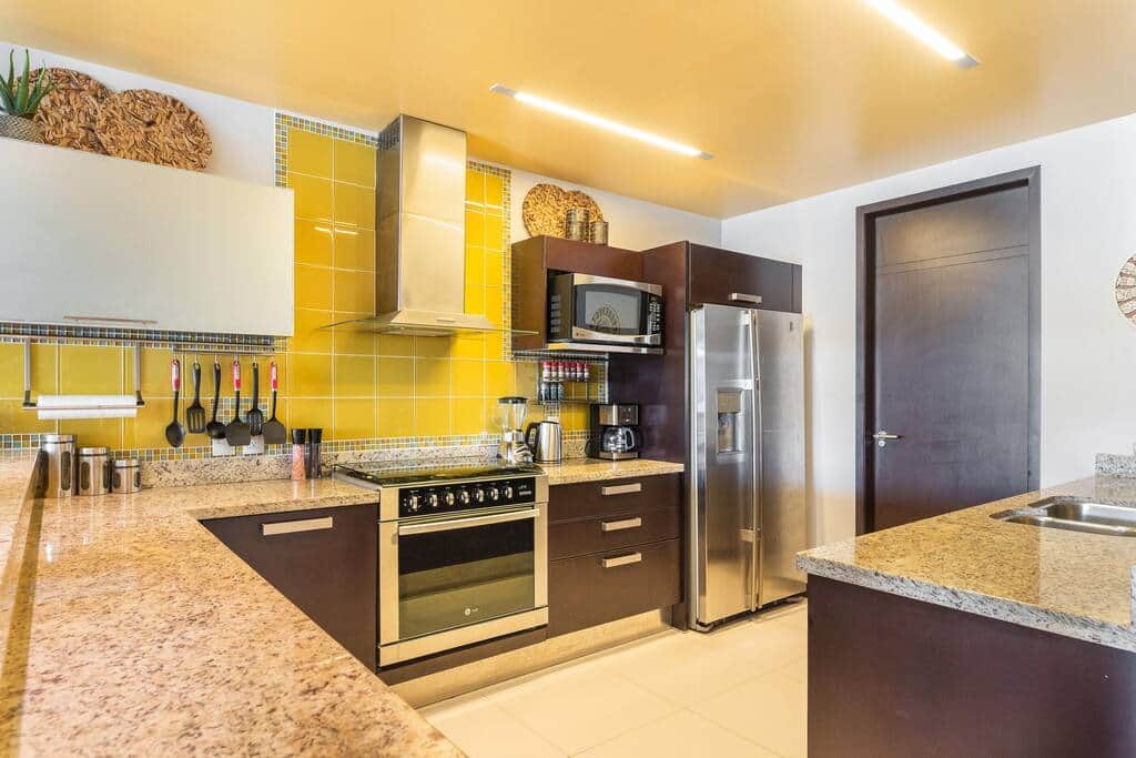 A large kitchen with stainless steel appliances (gas range, double door refrigerator and dishwasher)