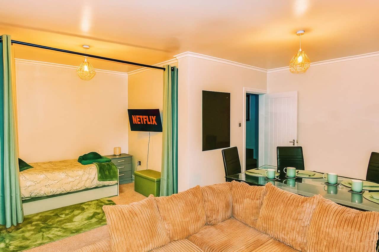 Living room with trundle bed, dining area, sofa and smart TV with wireless mobile screen sharing