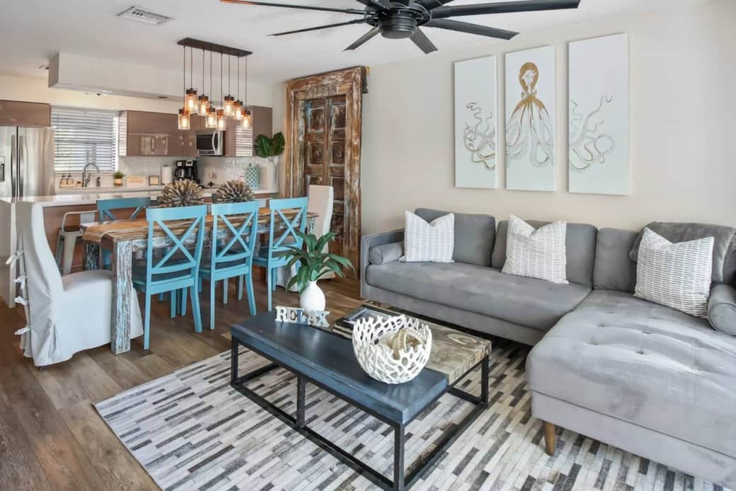 The living and dining space features a stunning antique wood door accent wall that adds character and charm.