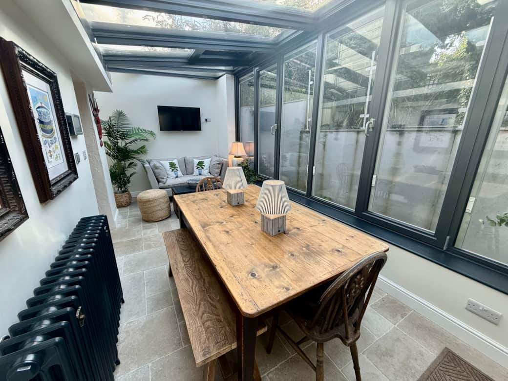 Spacious dining area with large rustic wooden table and vintage bifold doors