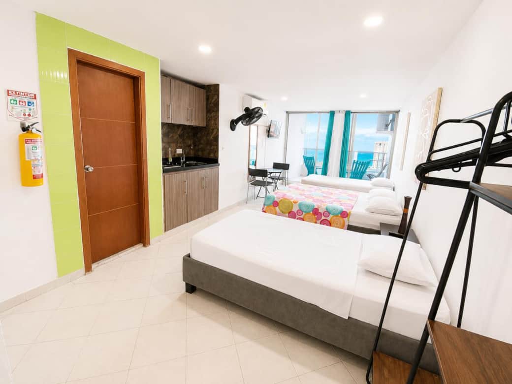 Dos camas sencillas y cama doble, cocina, vista al balcón