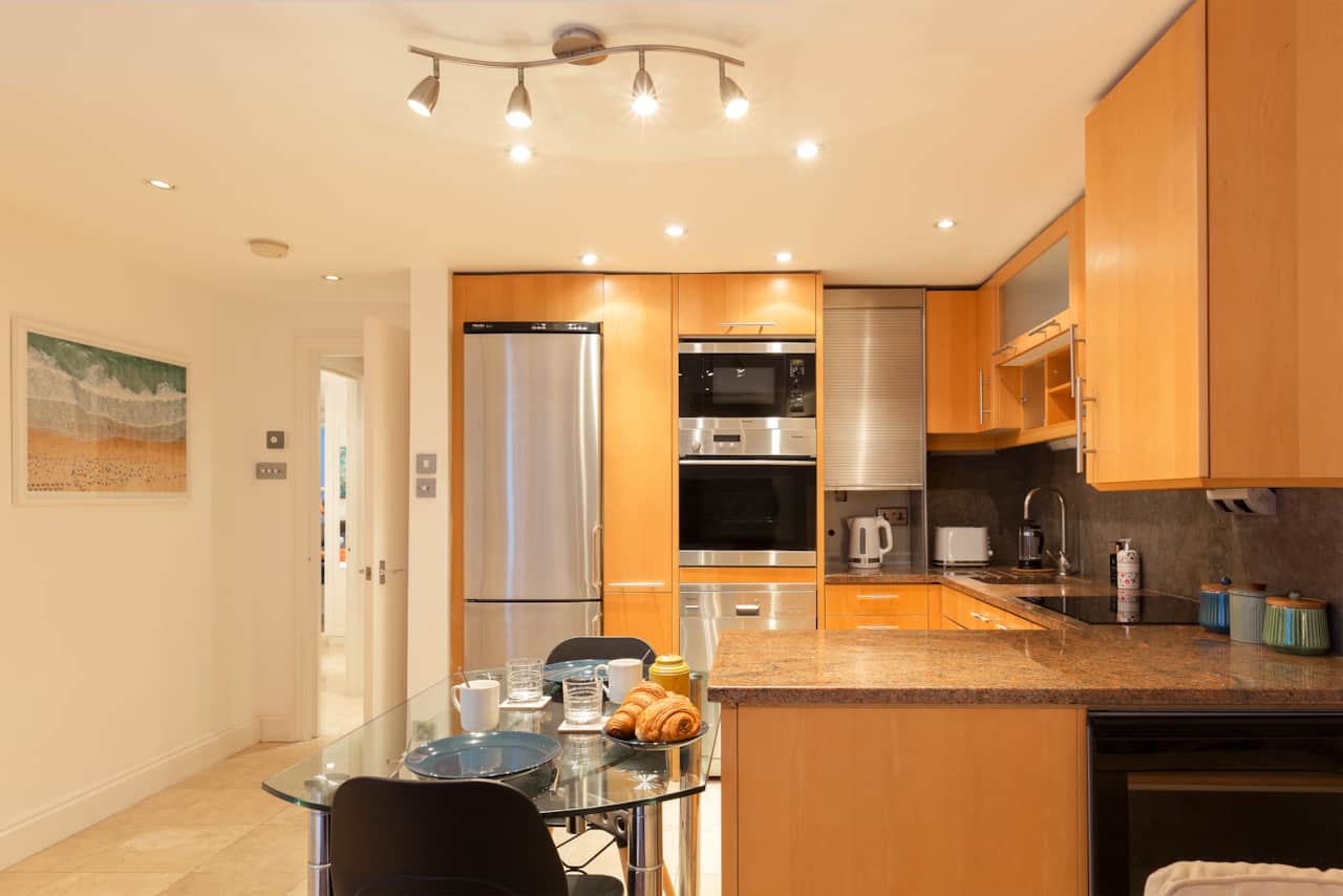 Kitchen with wall oven, microwave and breakfast table set for two