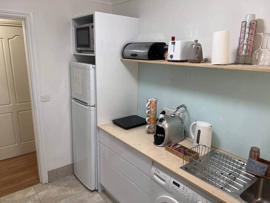 Kitchen with full fridge, induction cooktop, kettle and microwave Kitchen with full fridge, induction cooktop, kettle and microwave