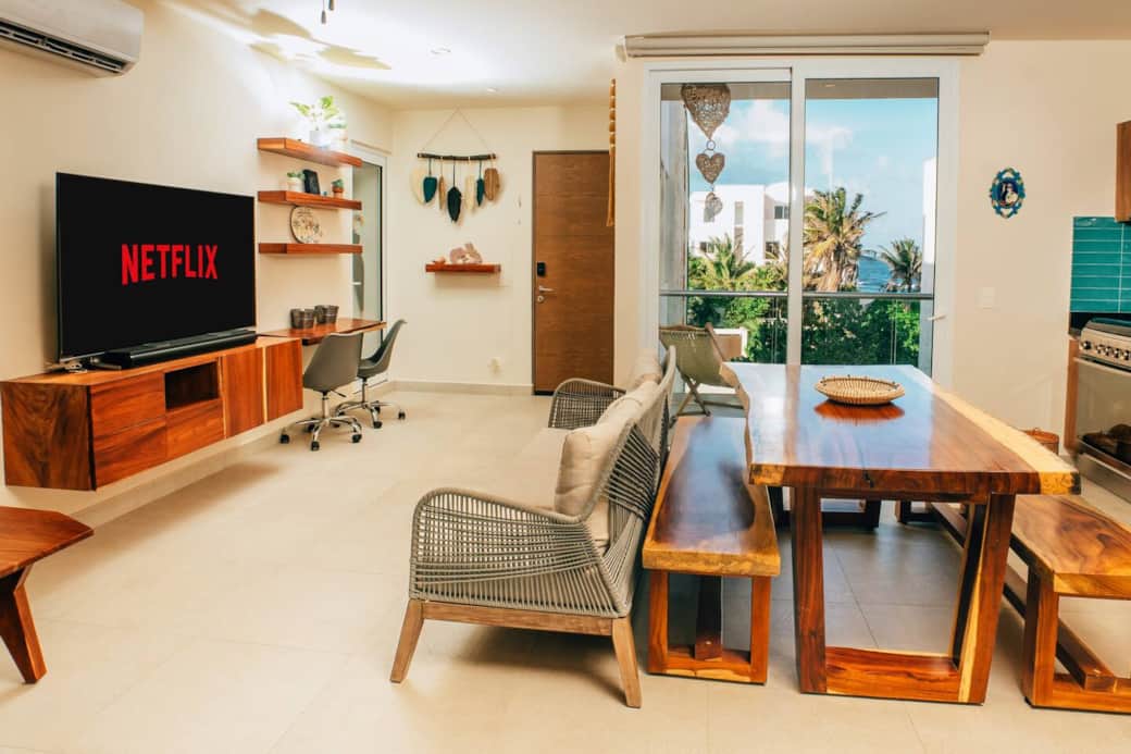 Enjoy the living room with air conditioning, ceiling fan, smart TV, and comfortable seating. Open the sliding doors for direct access to a private balcony with ocean views, perfect for relaxing and enjoying the Caribbean breeze.