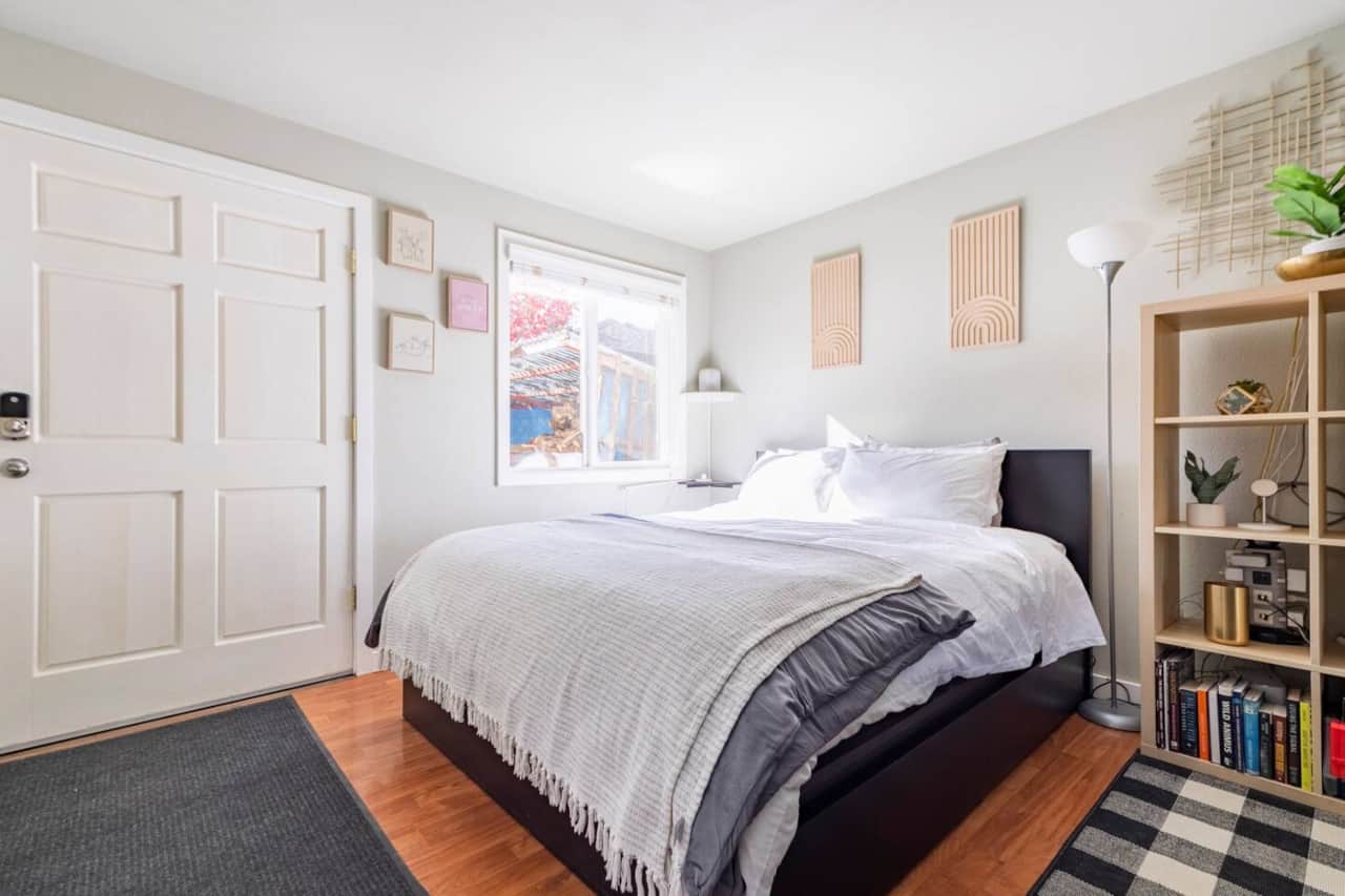 Queen bed with luxury linens, blackout curtains, and bedside charging ports