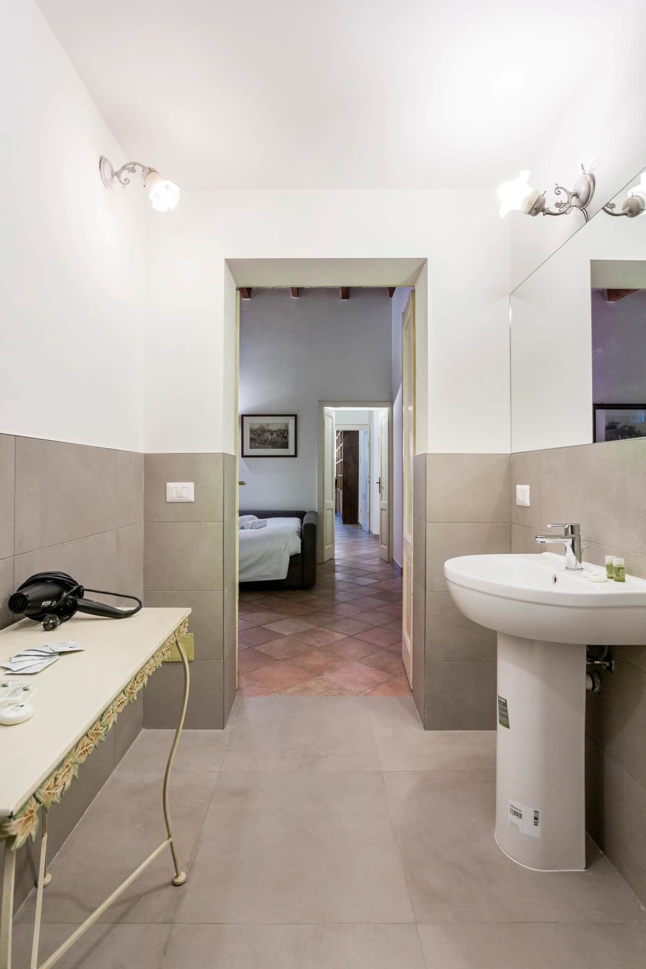 Bad mit Waschbecken, Spiegel und Flur zum Schlafzimmer