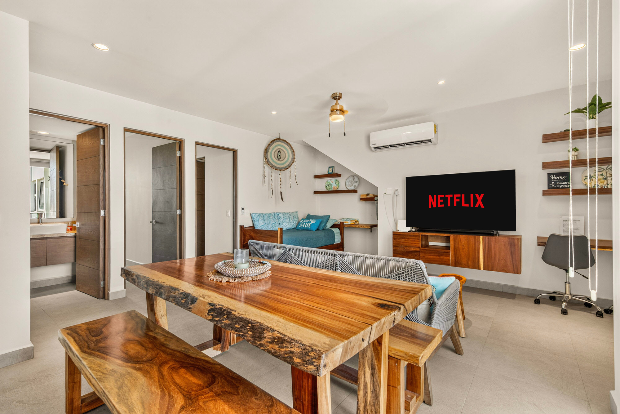 Gather at the handcrafted wooden dining table for six and enjoy meals while watching the smart TV.