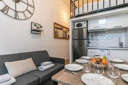 Salon avec coin repas et cuisine équipée 