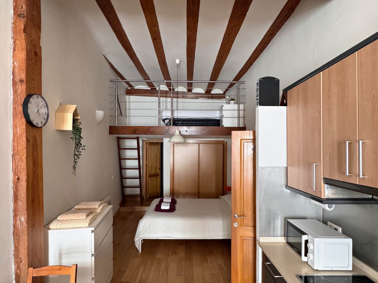 Estudio con vigas de madera y altillo