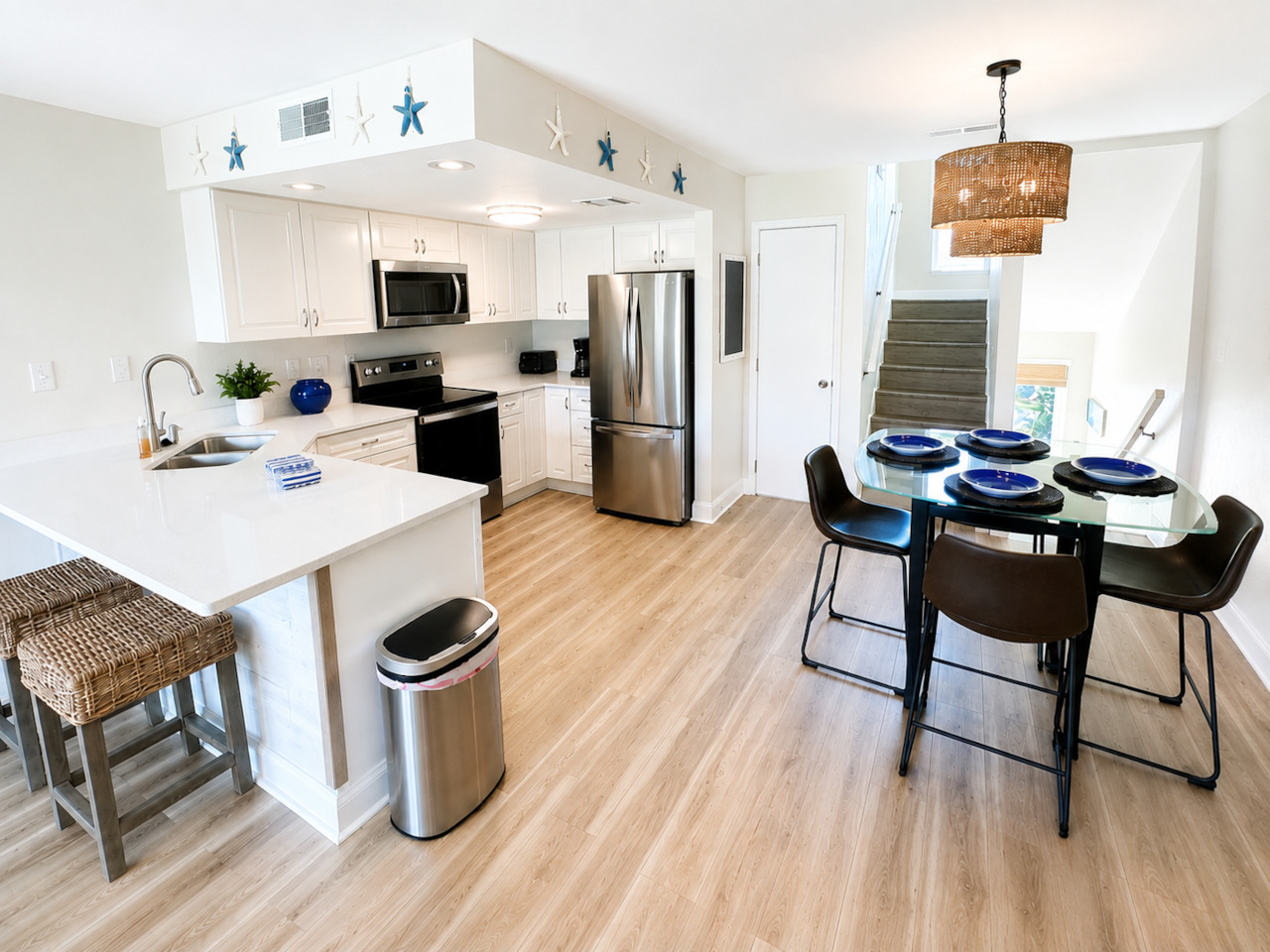 Renovated coastal kitchen with quartz countertops and stainless steel appliances.