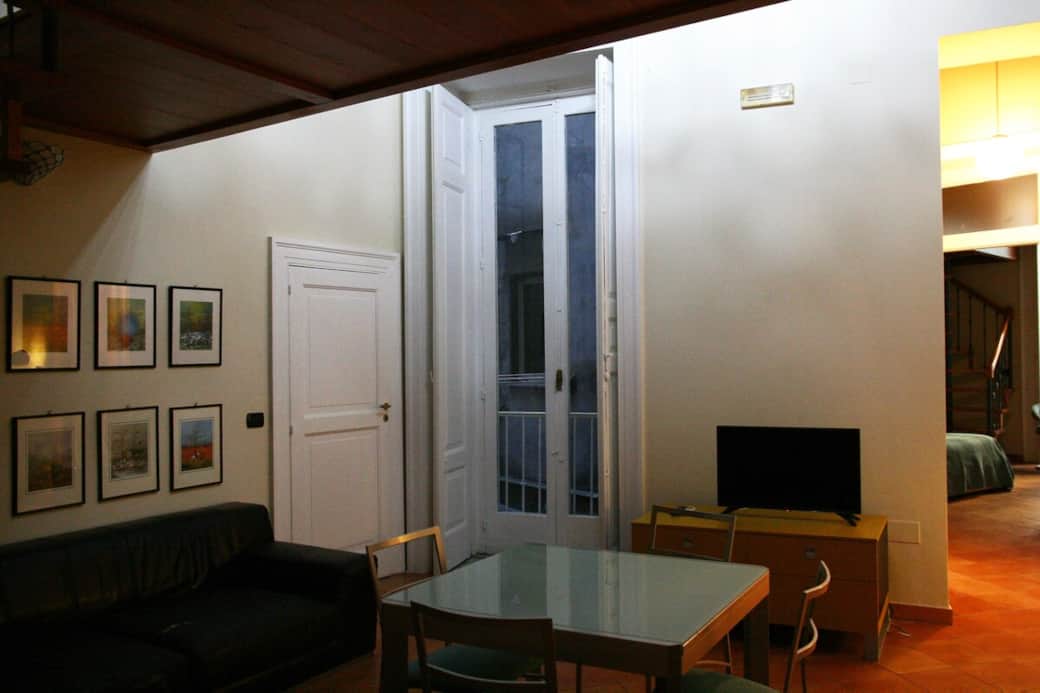 Another view of the living room with TV and access to the main bedroom. The balcony is on the internal courtyard of the building