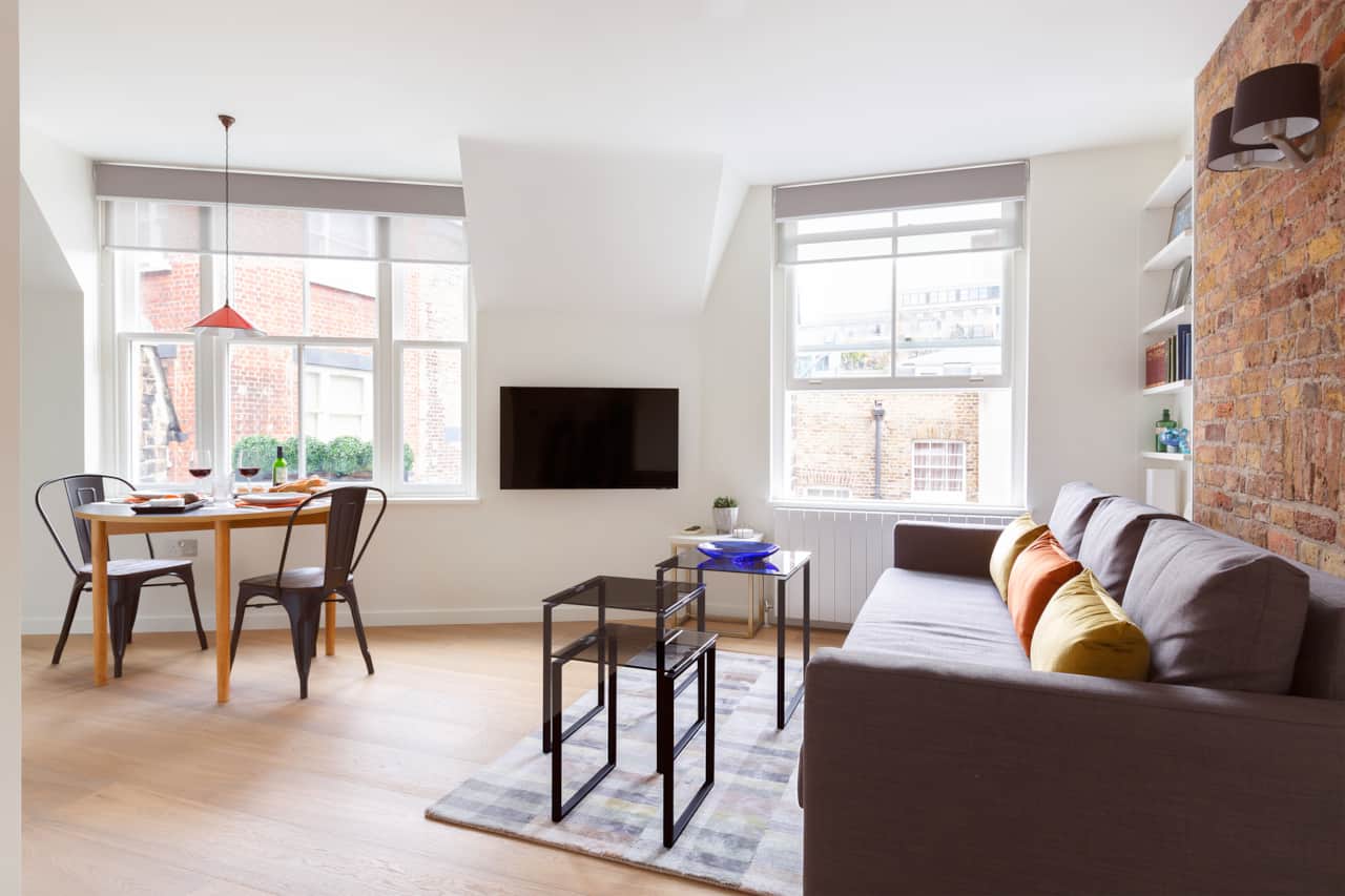 Living and dining area with exposed brick and city rooftop views