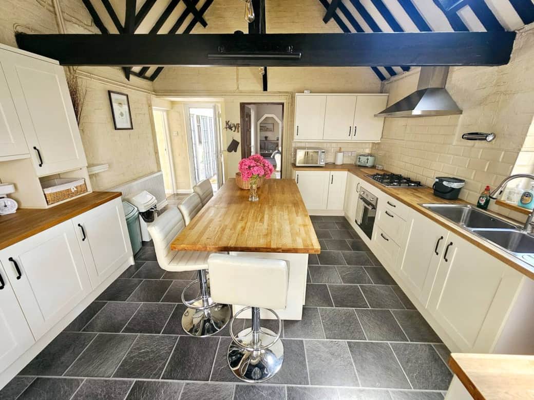Large fully loaded kitchen stocked full with supplies, and a breakfast bar island.