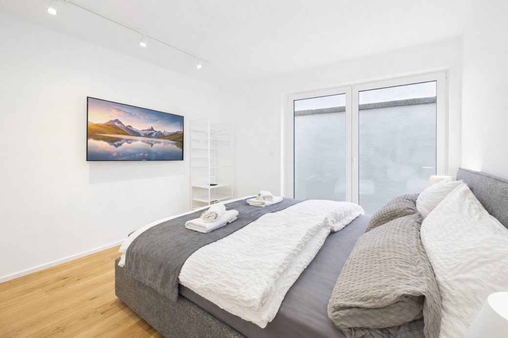 Ruhiges Schlafzimmer mit komfortablem Queensize-Boxspringbett (160x200) und Smart-TV