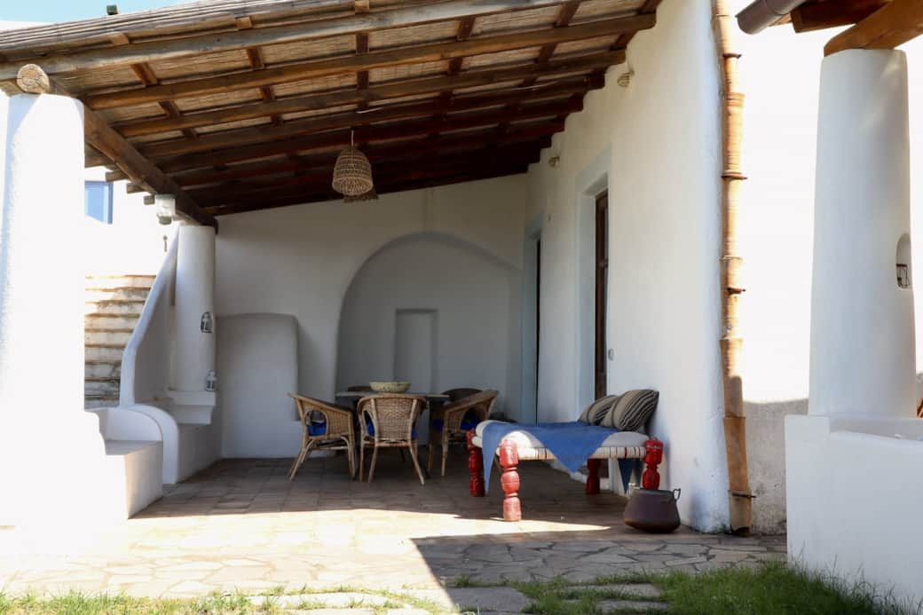 Patio coperto con arredi in vimini e zona relax a Villa Agave.
