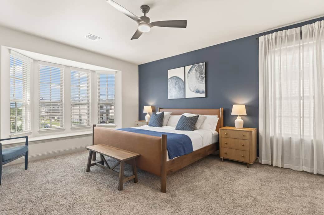 Primary suite with Tempur-Pedic ProAdapt king bed, executive furnishings, and smart TV. Bay window offers natural light, privacy blinds, and unobstructed views—ideal for restful nights and productive mornings.