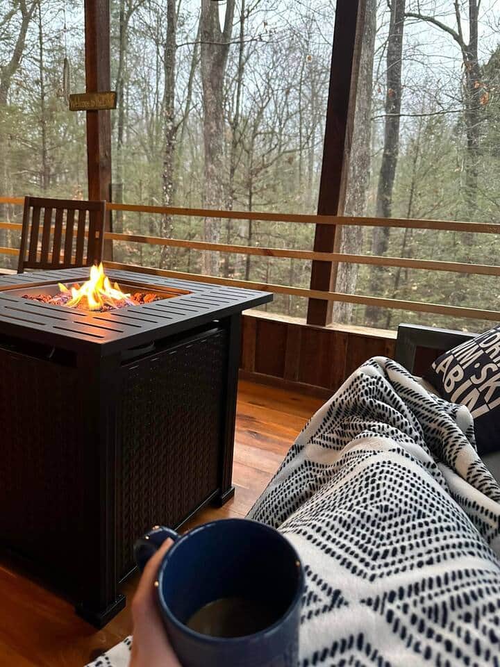 A large exterior screened in porch awaits with a card table, comfortable patio furniture and a propane fire table. What is the best part?  The back porch overlooks the waterfall.  Spring & winter are the best times to enjoy the falls. 