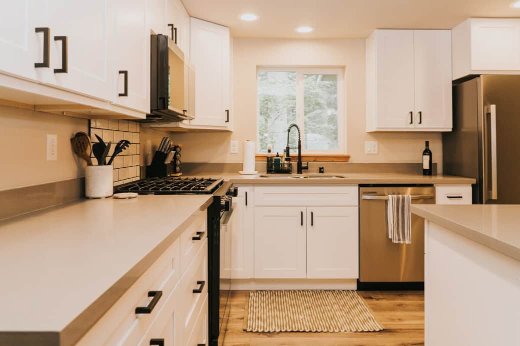 Enjoy a fully equipped kitchen with stainless steel appliances, a gas range, dishwasher, full-size refrigerator, spacious island, and forest views.