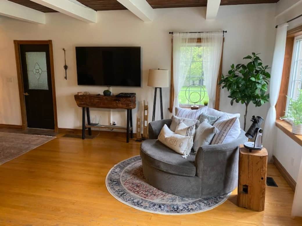 Family room with sectional couch, cuddler couch, electric fireplace, 65 inch smart TV, and vinyl record player.