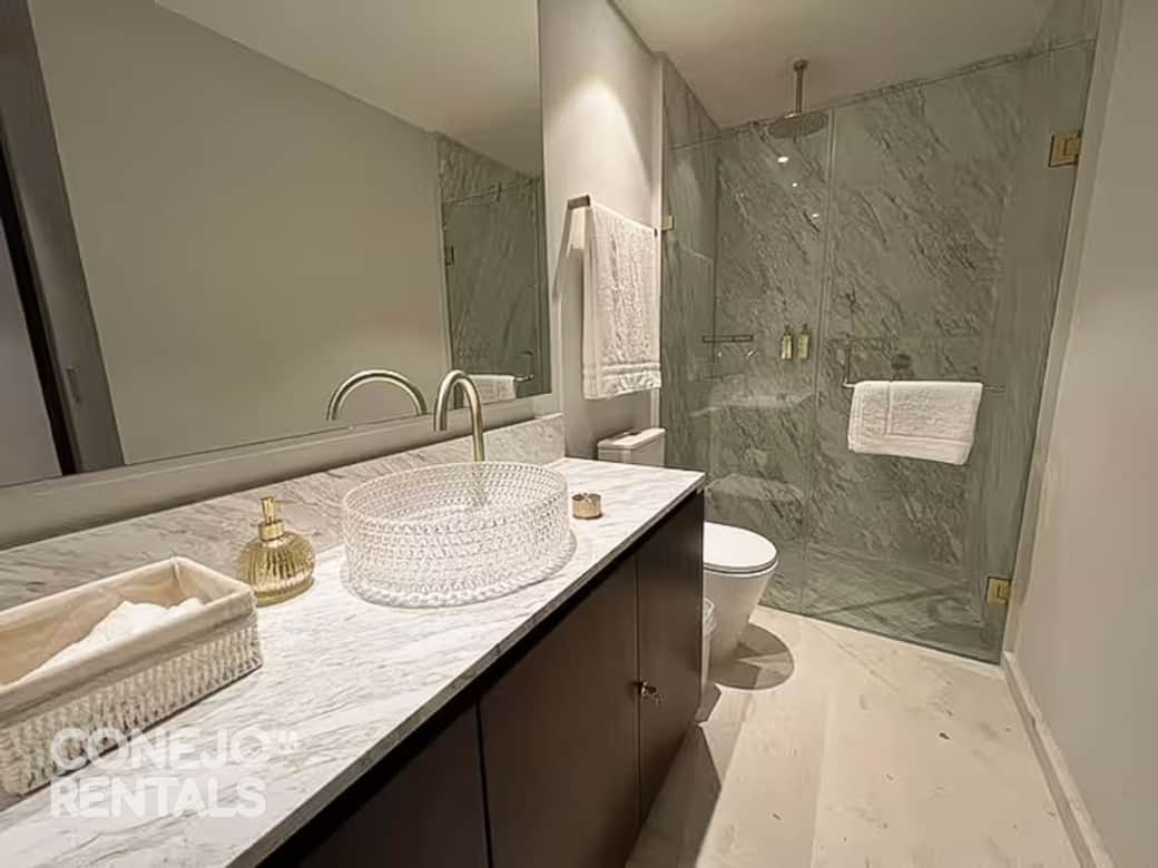 Baño moderno en Bolongo con mármol y detalles dorados sofisticado y completo Baño moderno en Bolongo con mármol y detalles dorados sofisticado y completo