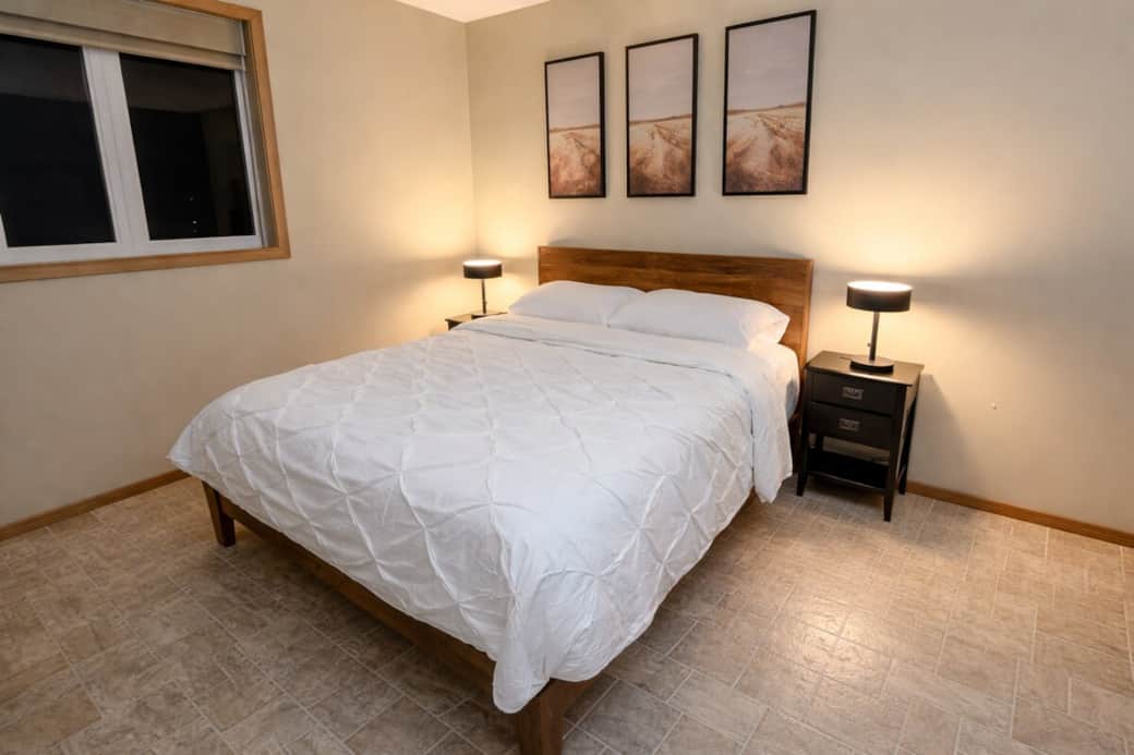 Cozy guest bedroom featuring warm ambient lighting and soft linens