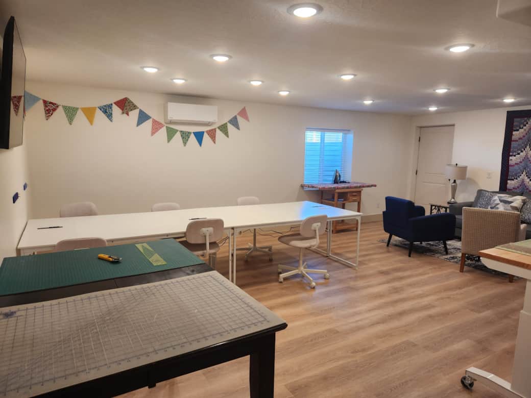 Sewing studio for six has two cutting tables, two ironing stations, and comfortable sewing chairs. Sewing studio for six has two cutting tables, two ironing stations, and comfortable sewing chairs.