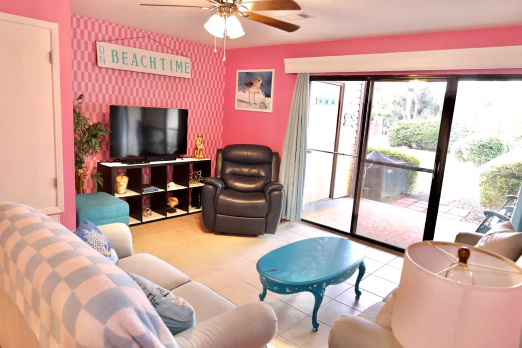 Living room area with TV, lounge chair, and queen sofa bed