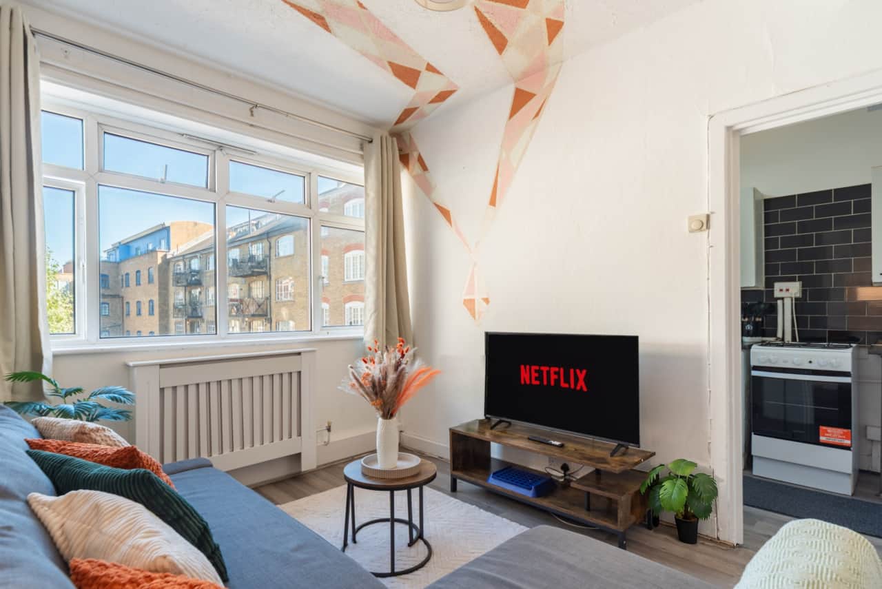 Spacious living room with a comfy sofa, widescreen smart TV with Netflix and a coffee table.