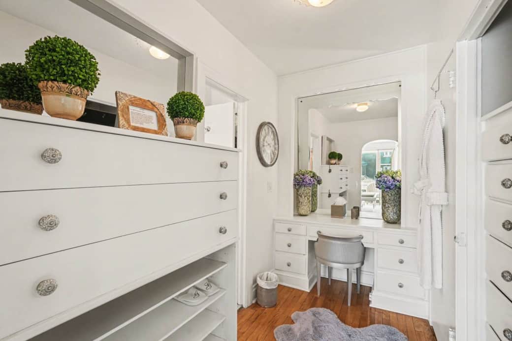 Modern dresser and vanity area with large mirror and bright lighting Modern dresser and vanity area with large mirror and bright lighting