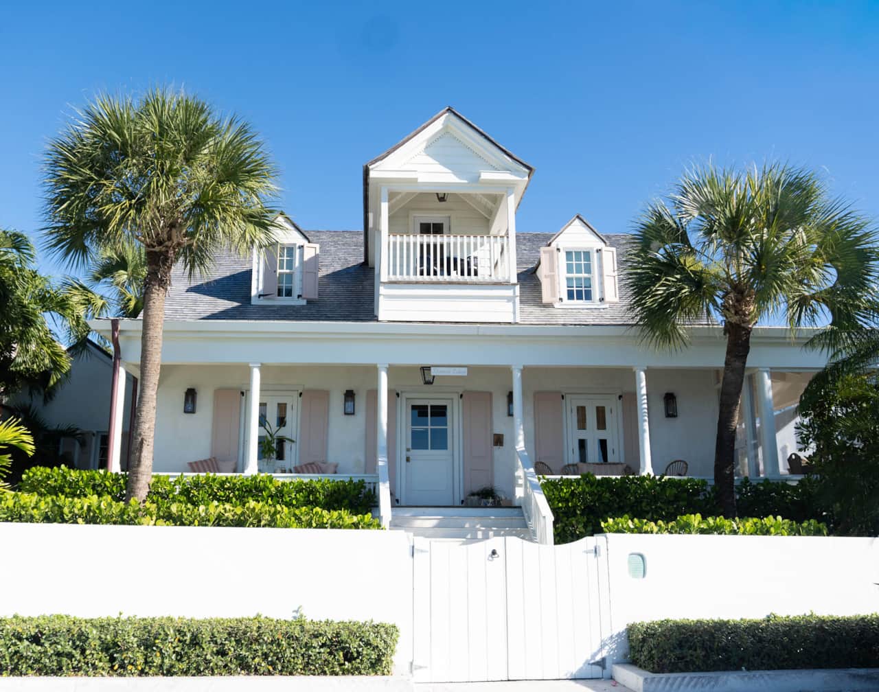Dunmore Cottage from Bay Street, wraparound porch, pink shutters, and a walled garden