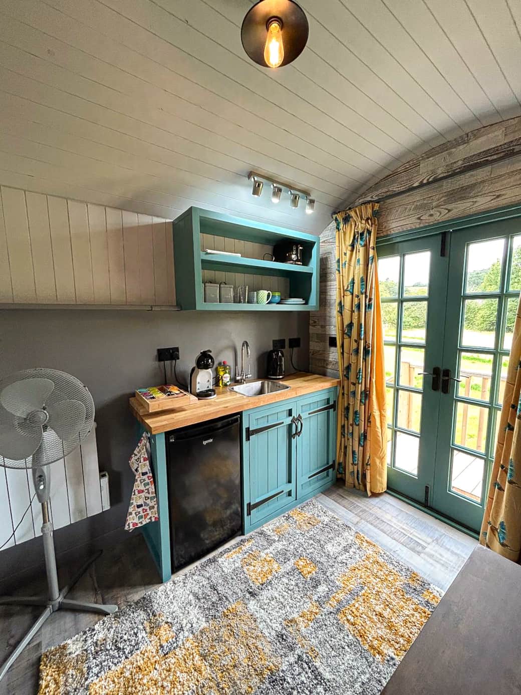 Cosy dining nook with French doors framing peaceful countryside views.