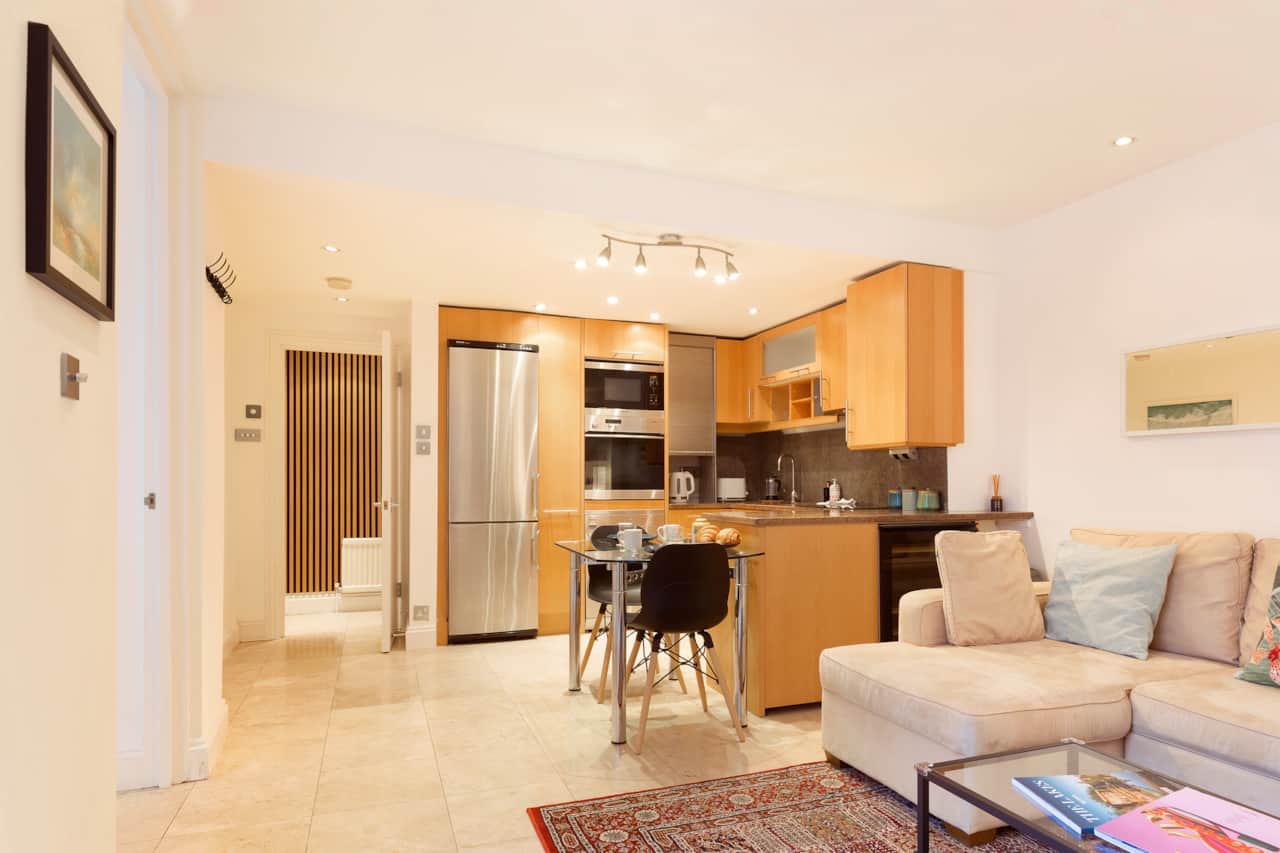 Fitted kitchen with stainless steel fridge and integrated oven and microwave