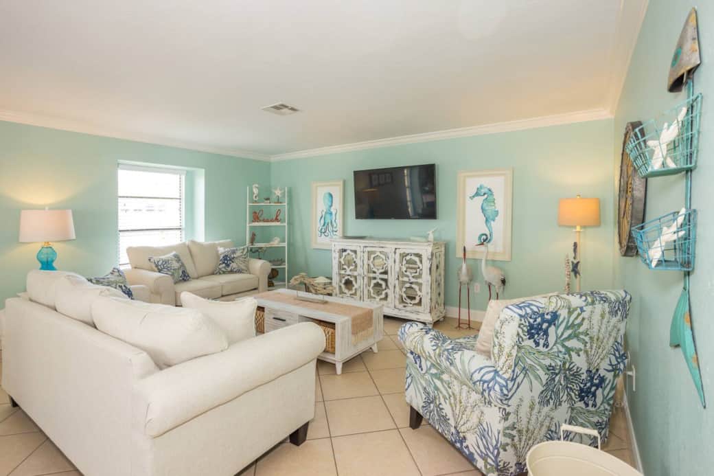 Comfy coastal nights—plush sofas, a cozy lounge chair, smart TV, island-time glow.