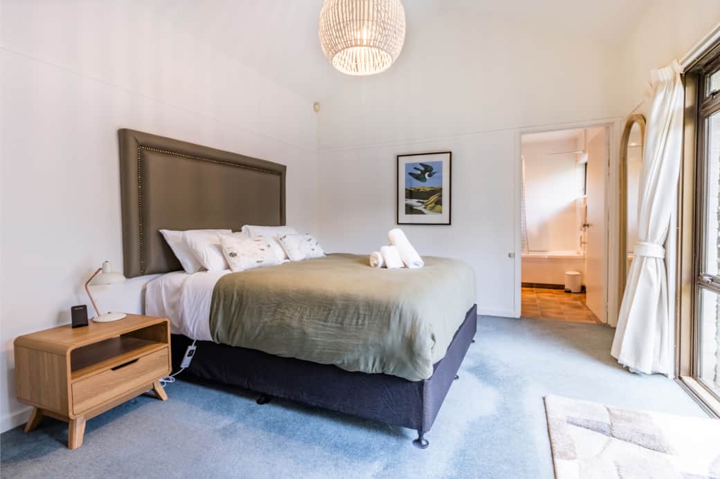 King bed, NZ art, patio access, and private ensuite — the perfect mix of comfort and style.