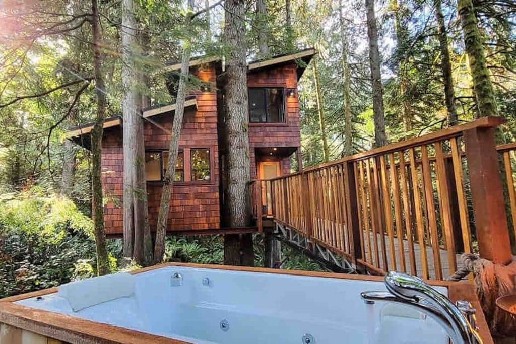 View of the treehouse from the outdoor tub and propane fire-pit.