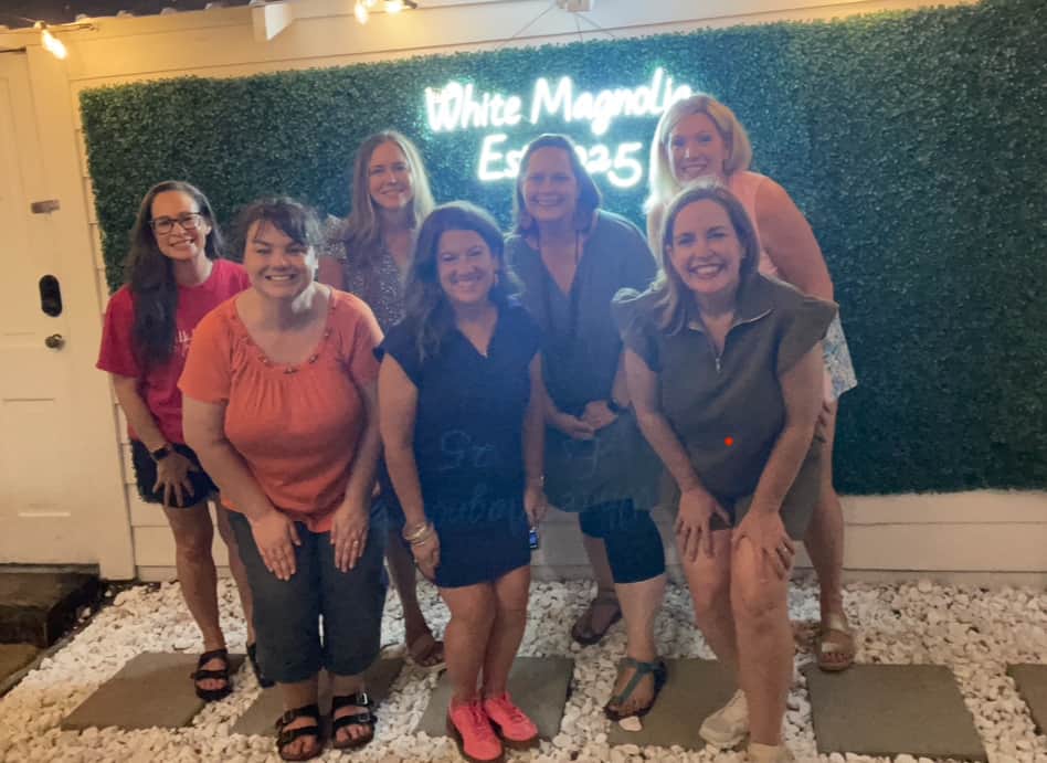 ladies-in-front-of-white-magnolia-sign-during-ladies-retreat