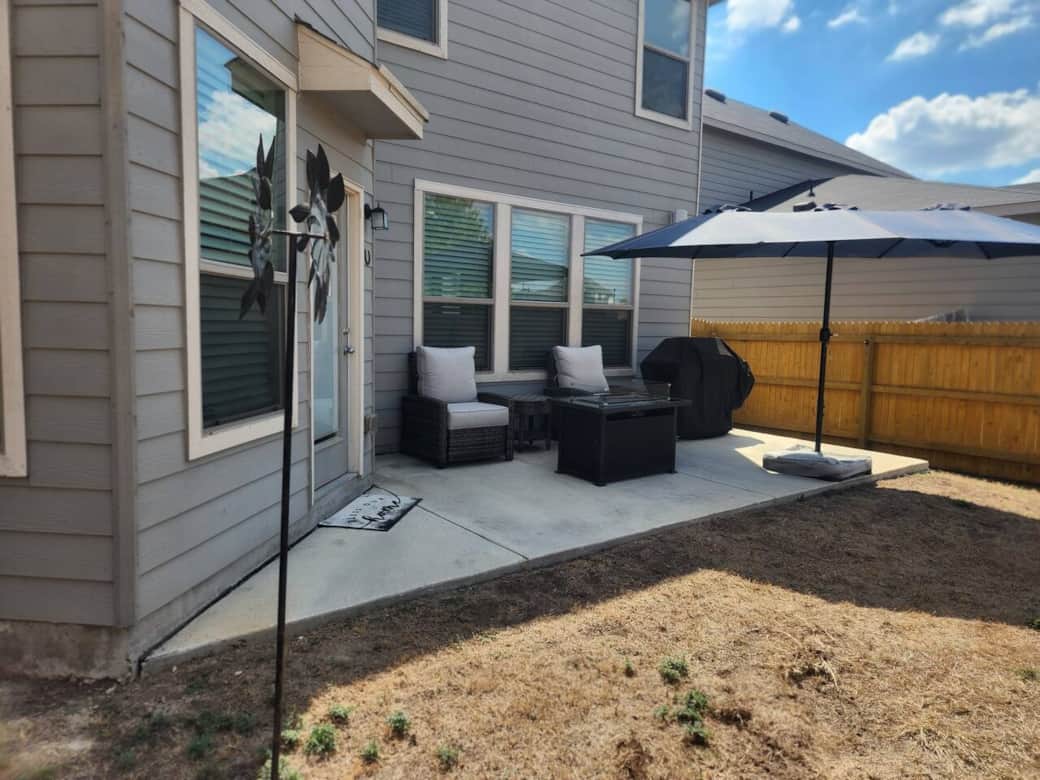 Hybrid gas and electric grill,  outdoor gas fireplace,  and large umbrella.
