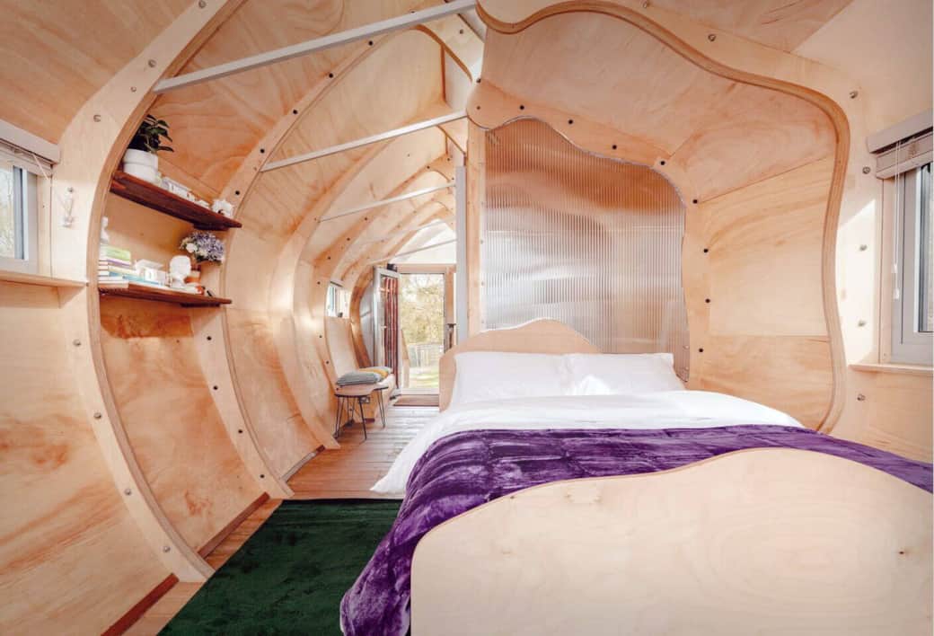 Bedroom with Wood Accents
Inviting bed framed by natural wood, creating a warm and restful space with forest views.