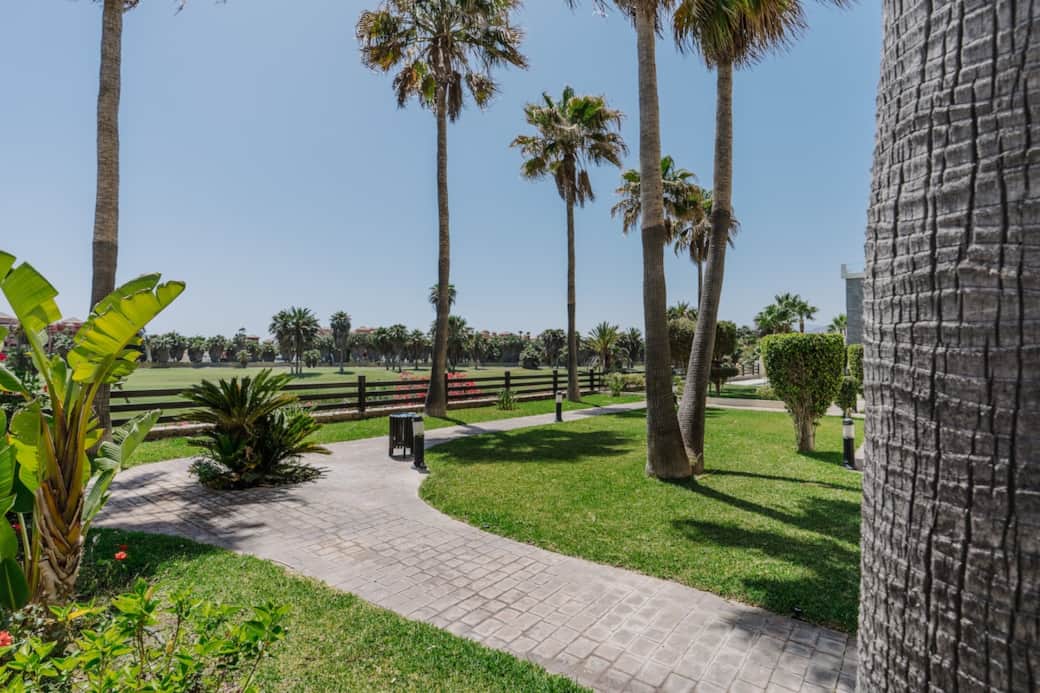Disfruta de vistas abiertas al campo de golf rodeado de flores y palmeras. Un entorno perfecto para pasear o jugar.
