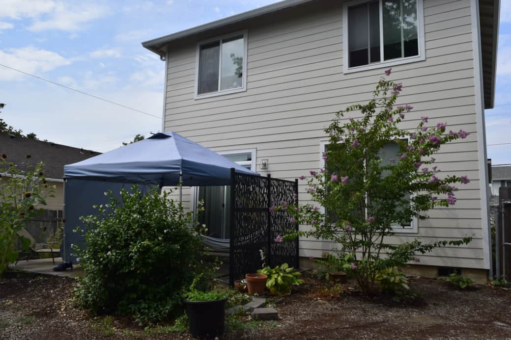Step out back to a private, spacious yard featuring a shaded patio canopy, raised garden beds, and p Step out back to a private, spacious yard featuring a shaded patio canopy, raised garden beds, and p